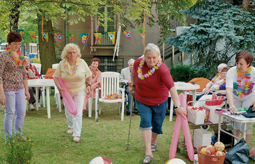 Ein Sommerfest im Garten der TAL Fünf Frauen in festlicher Kleidung feiern im Garten mit Dekoration und Lichtern.
