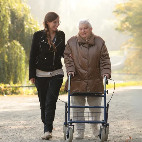 Spazierengehen am schönen Lietzensee Eine Pflegerin geht mit einer älteren Dame, die einen Rollator benutzt, am Lietzensee spazieren.